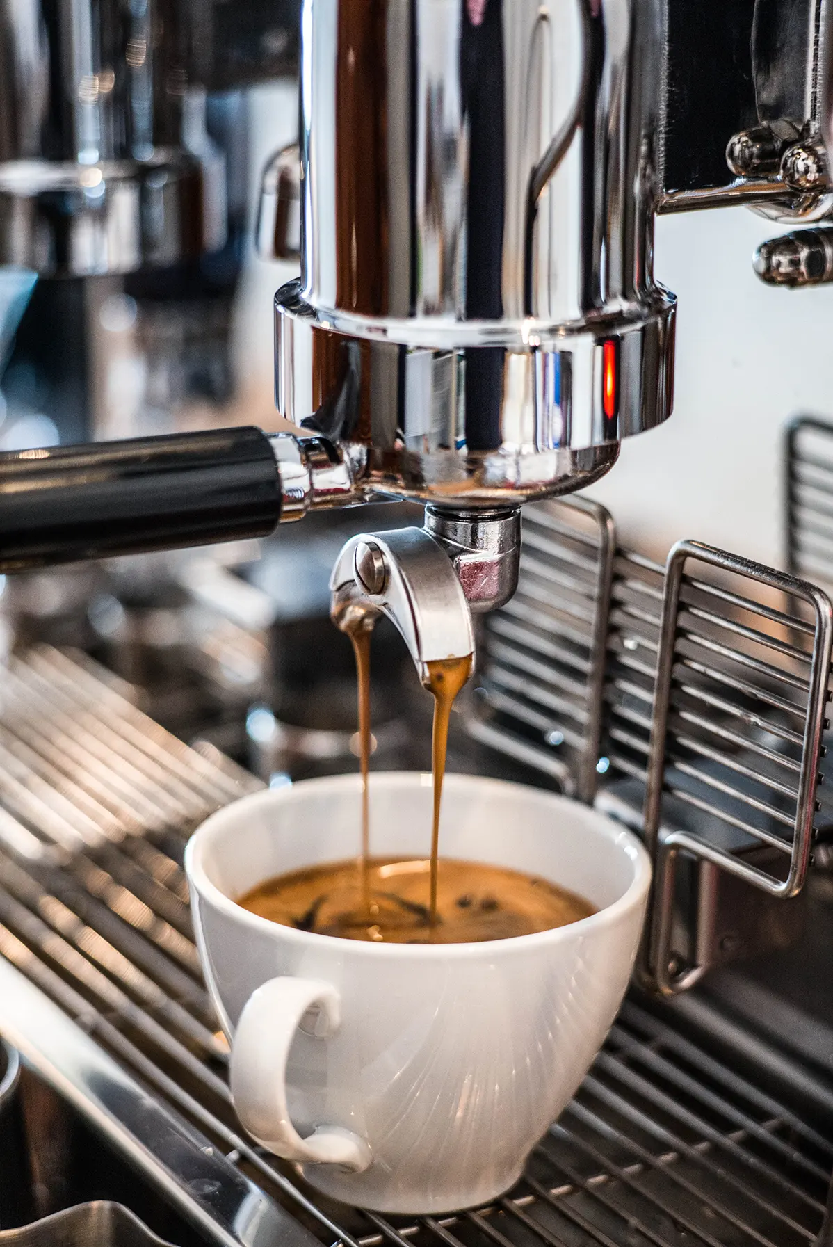 Espressomaschine bereitet Espresso in einer weissen Tasse zu.